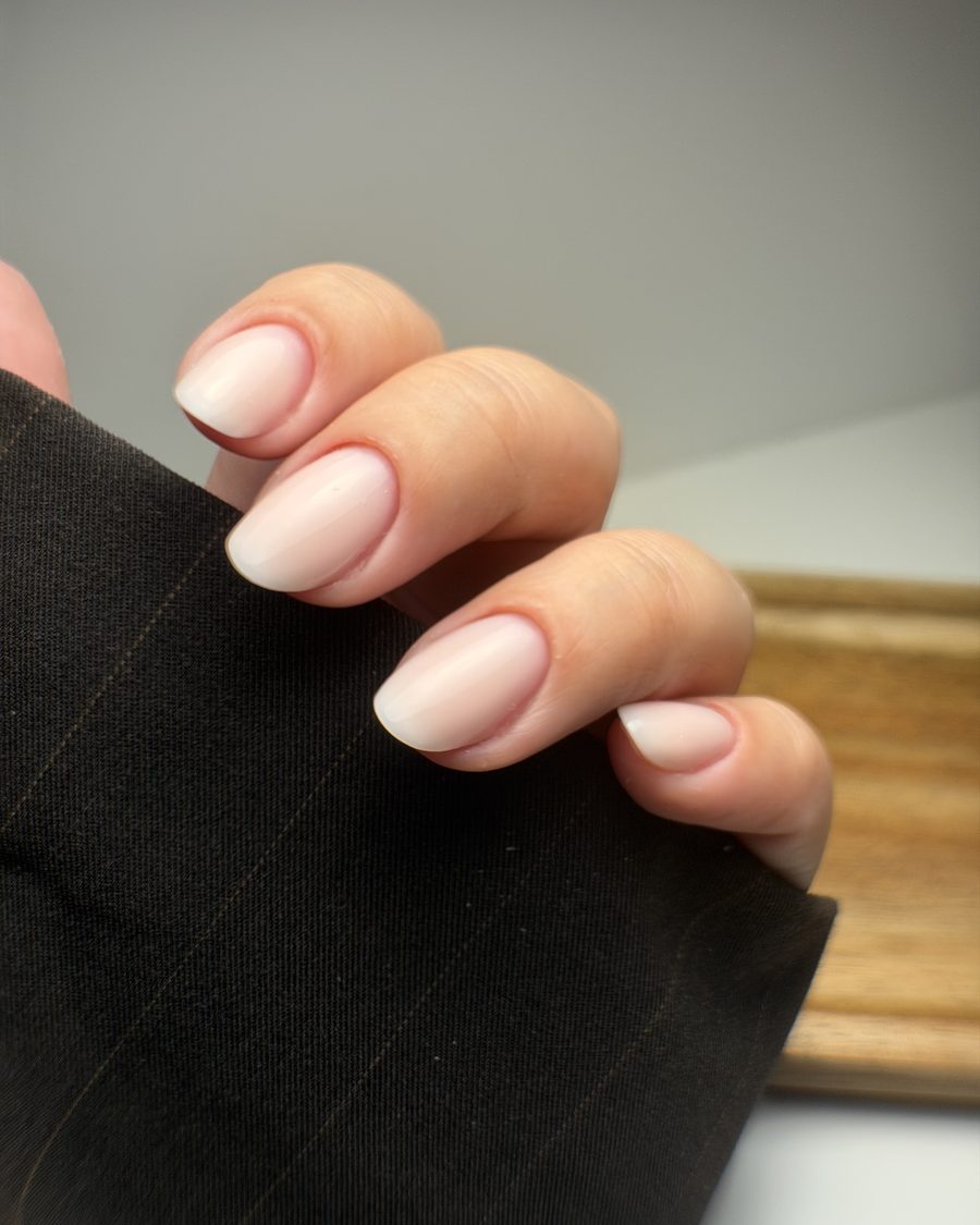 Extension, ongles en forme amande, mains posées sur un tissu sombre